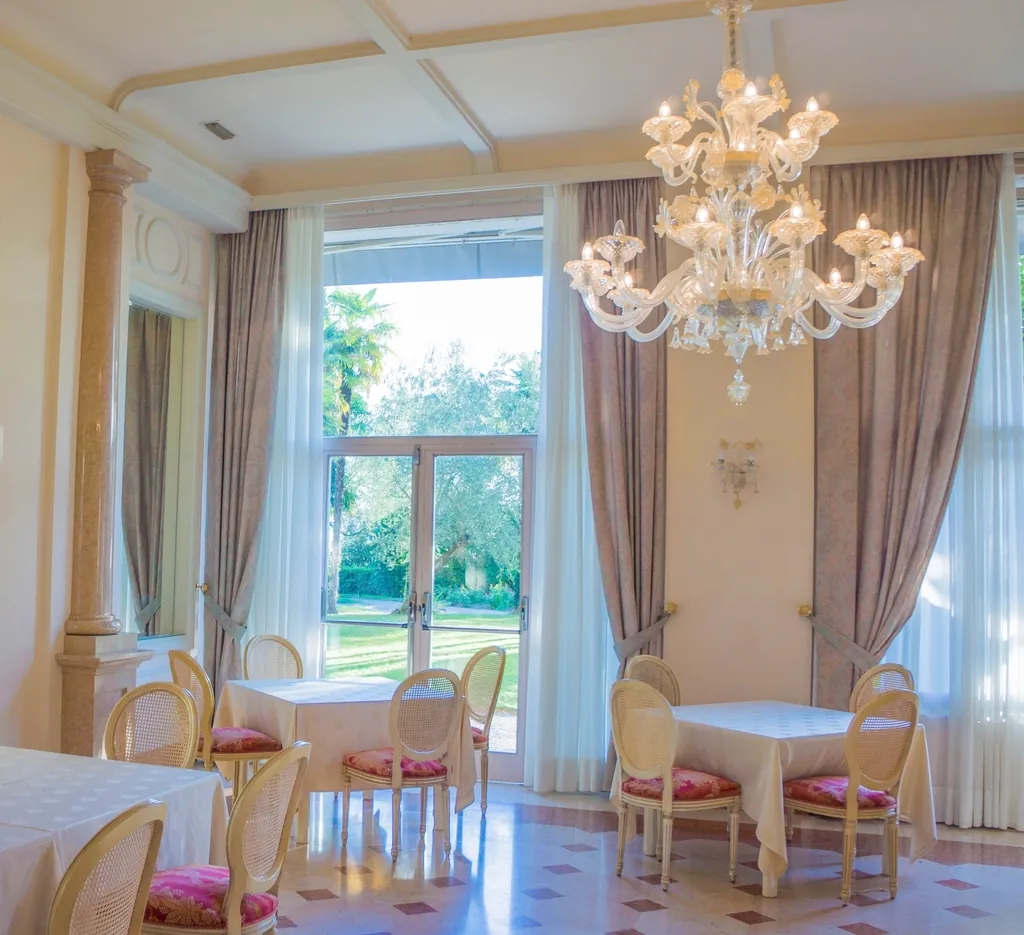 Elegant ballroom with tall windows and a crystal chandelier