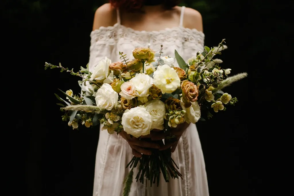 Bride holding a loose white and peach garden bouquet