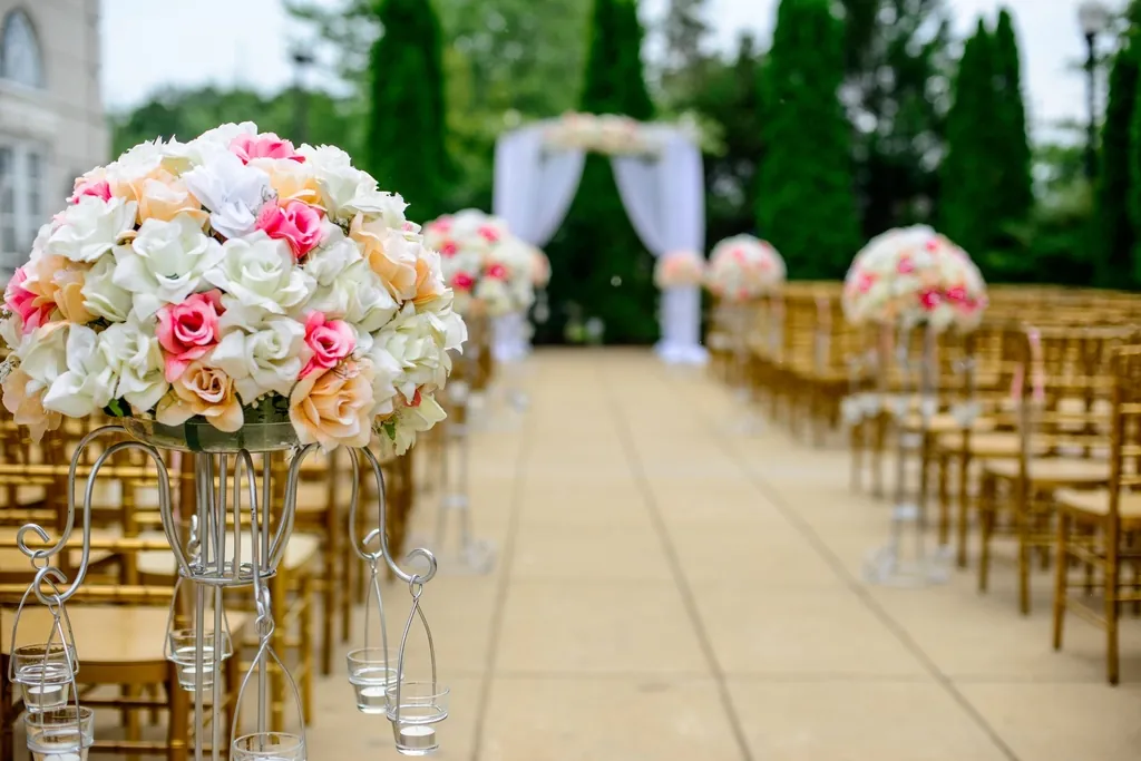 Wedding ceremony aisle lined with white and blush floral arrangements