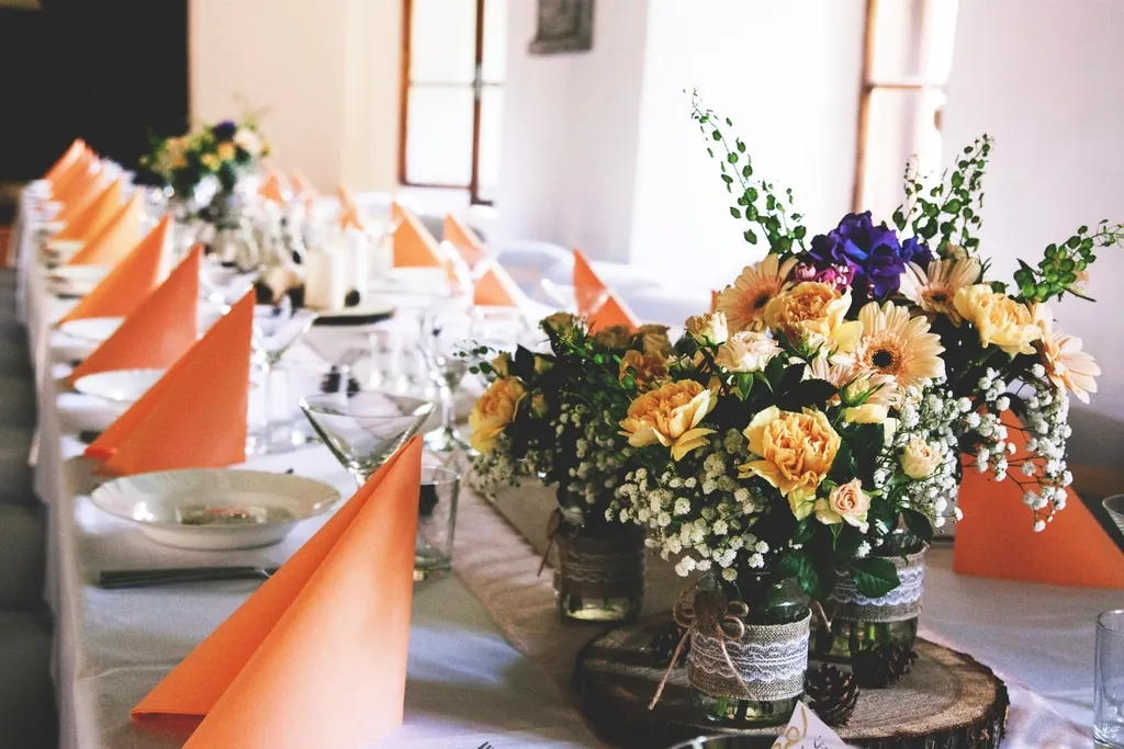 Long table with orange napkins and wildflower centrepieces