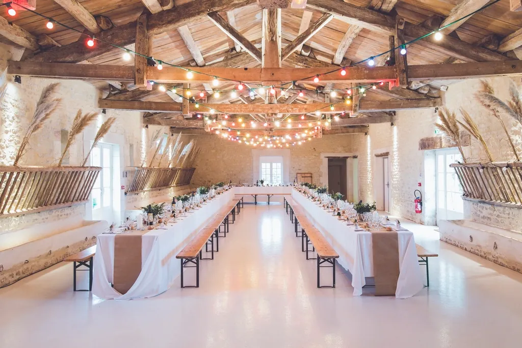 Reception hall with long tables under strings of lights