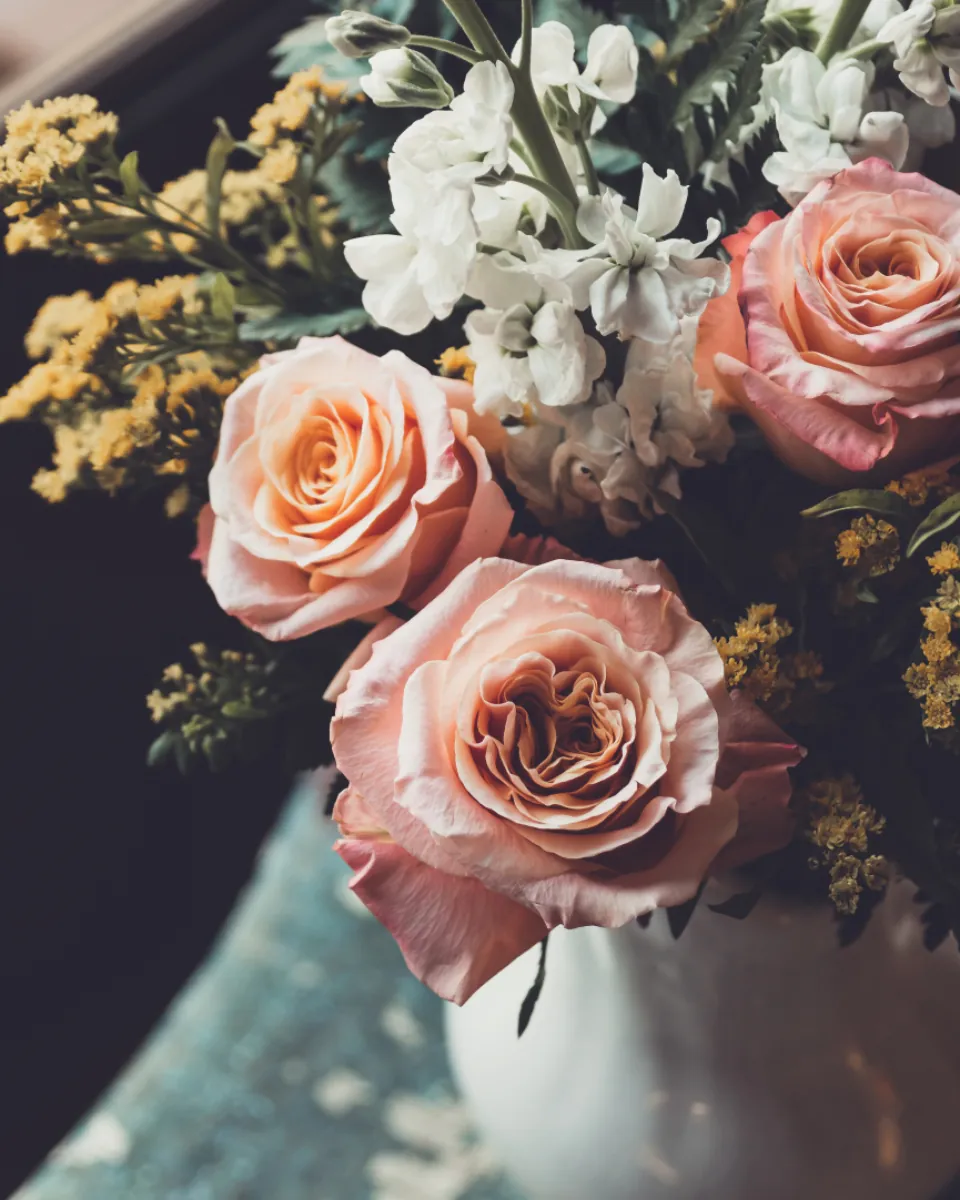 Peach roses and white blooms in a moody arrangement